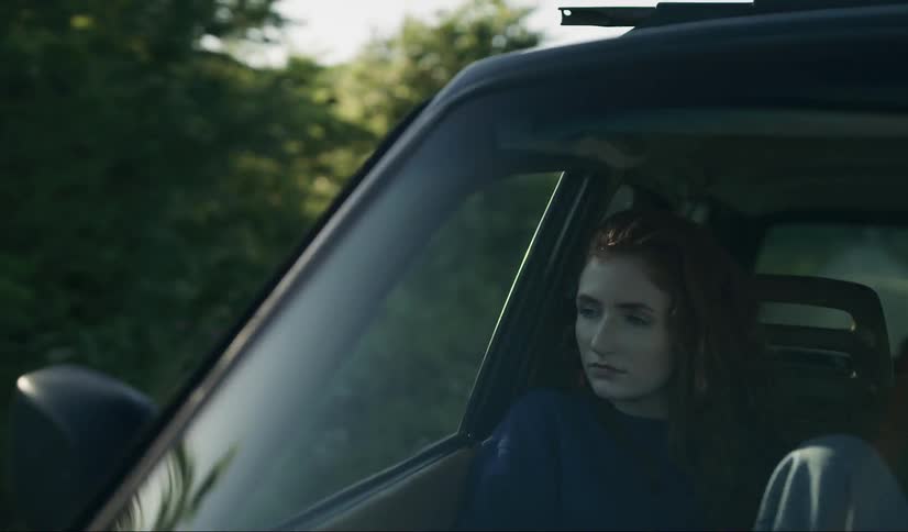 Woman rides in a car through the country on a sunny day