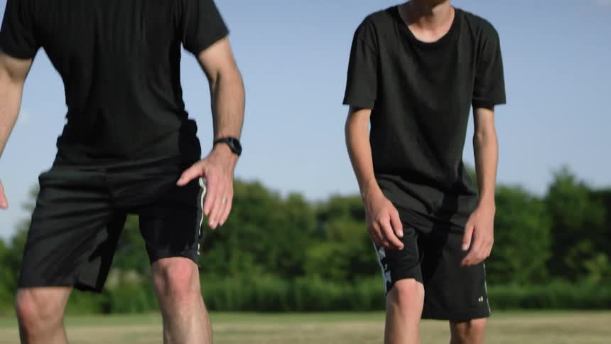 A man and a boy race in a field