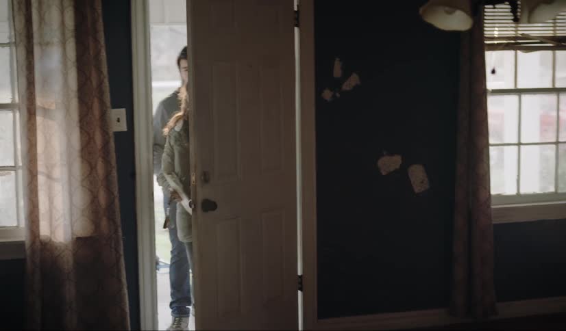 Two people run down the hall and other people walk in the door