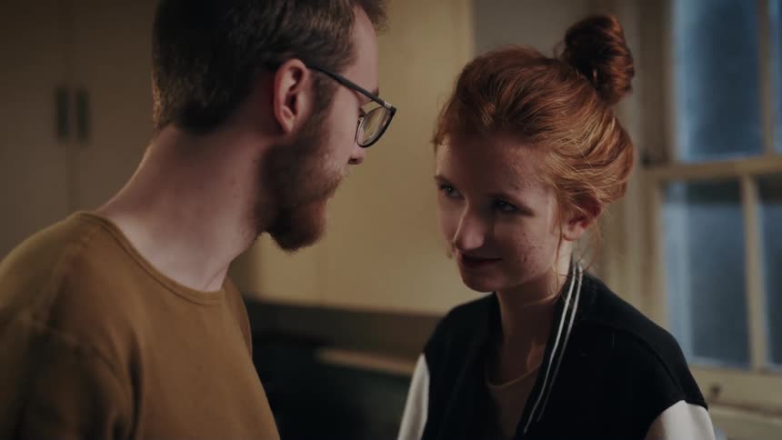 A man and a woman standing in a kitchen talking