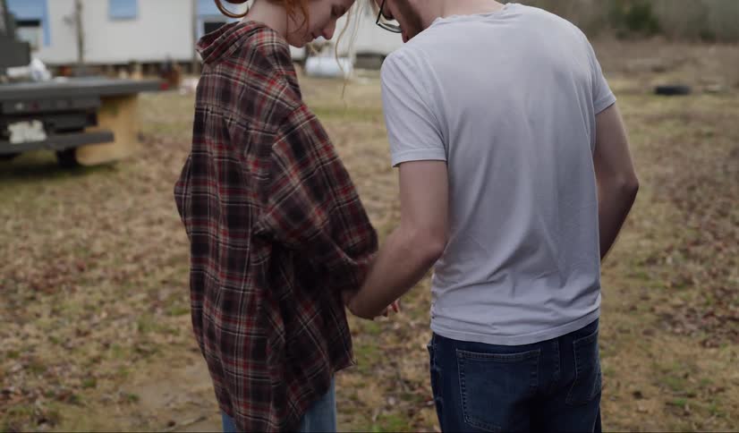 A man and woman hold hands and start walking
