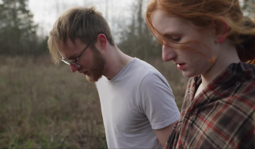 A man and woman walking in a field
