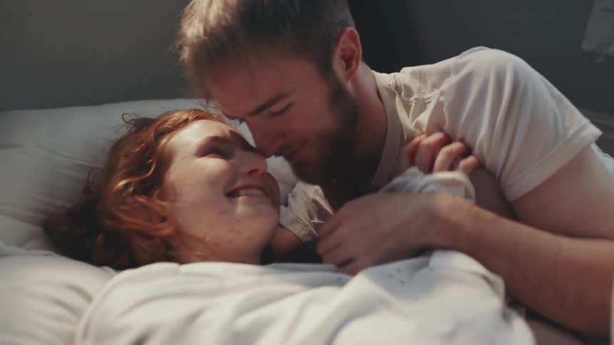 A man and woman playfully flirting while laying around