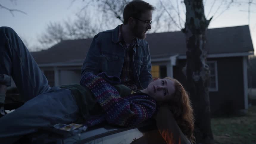A man is looking at a woman on a car