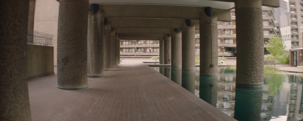 A building that has many pillars and is next to a reflecting pool