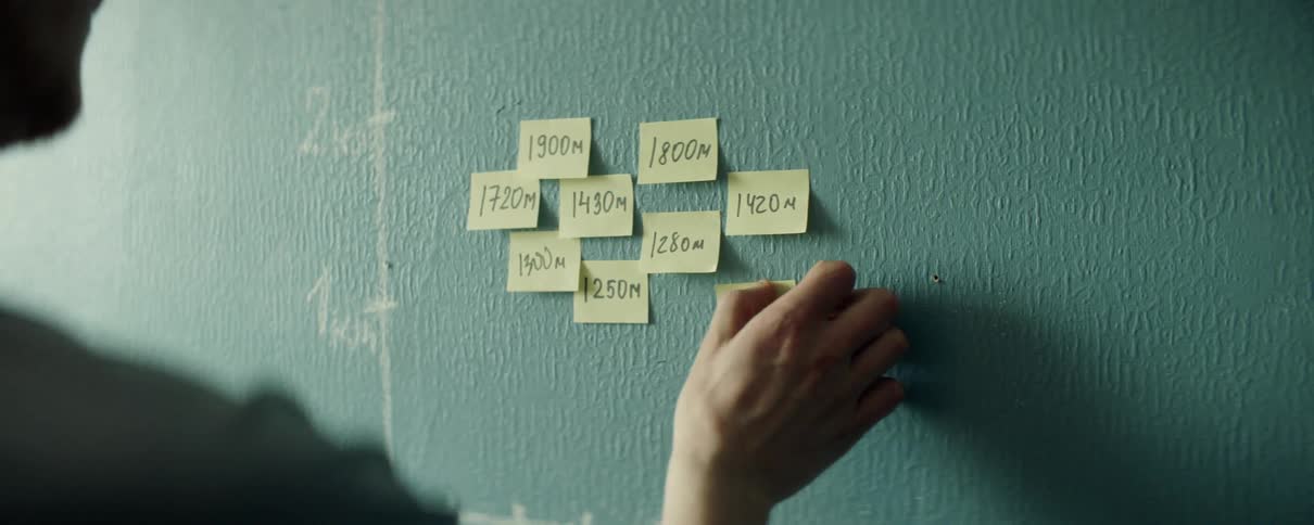 A person that is putting sticky notes up on a wall