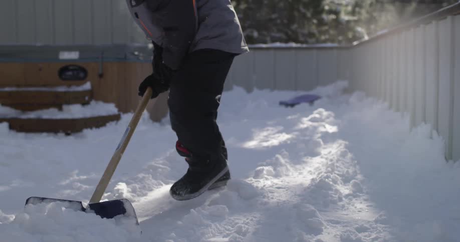 A child is shown shoveling snow