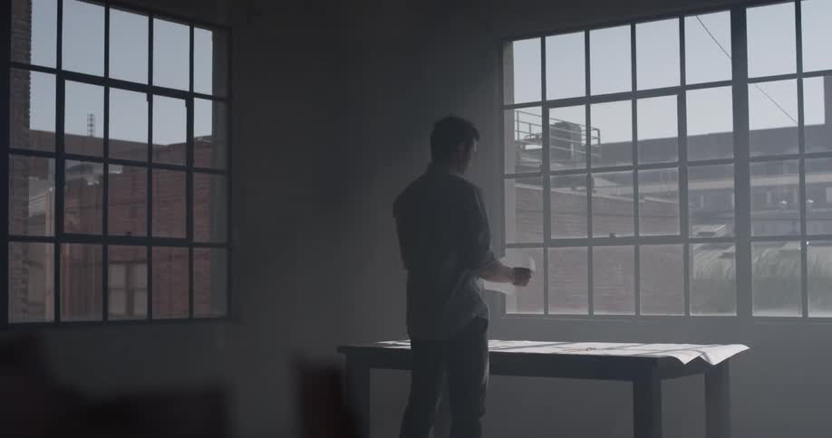 A man standing in an office looking out a window
