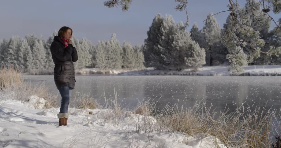 A woman is watching the snow on the lake