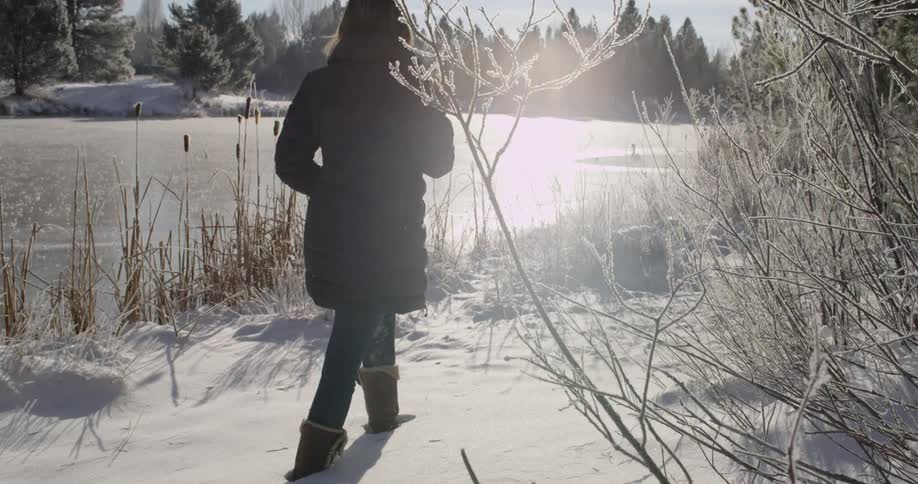 A woman is walking through the snow