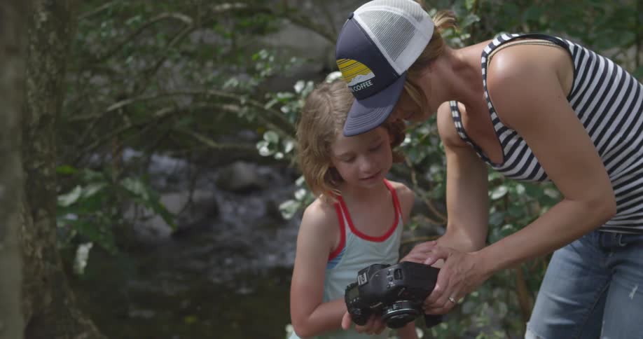 A woman is showing a child the camera