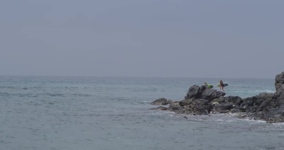 Surfers walking out into the beach