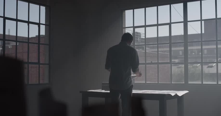 A man is walking to the table and writing on a piece of paper