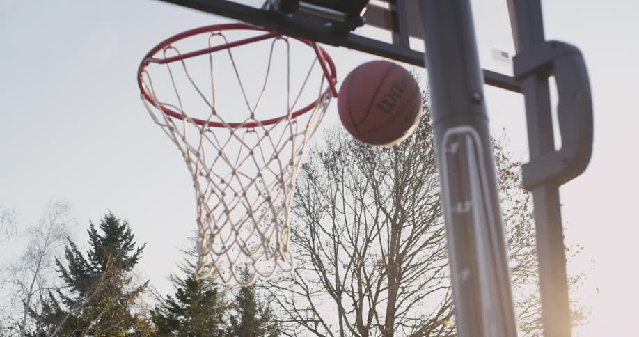A child shoots a basketball at an outdoor hoop