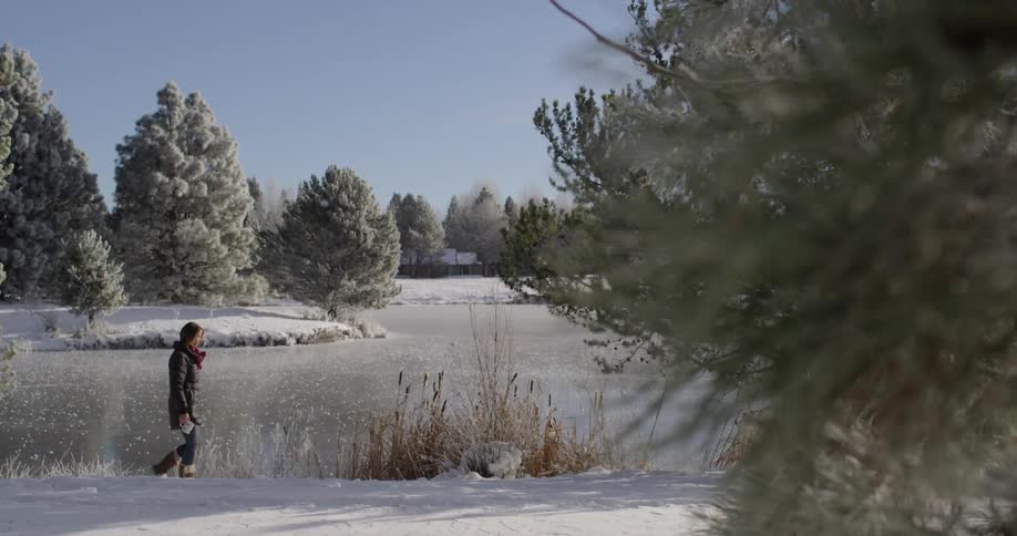 A woman is walking next to a pond