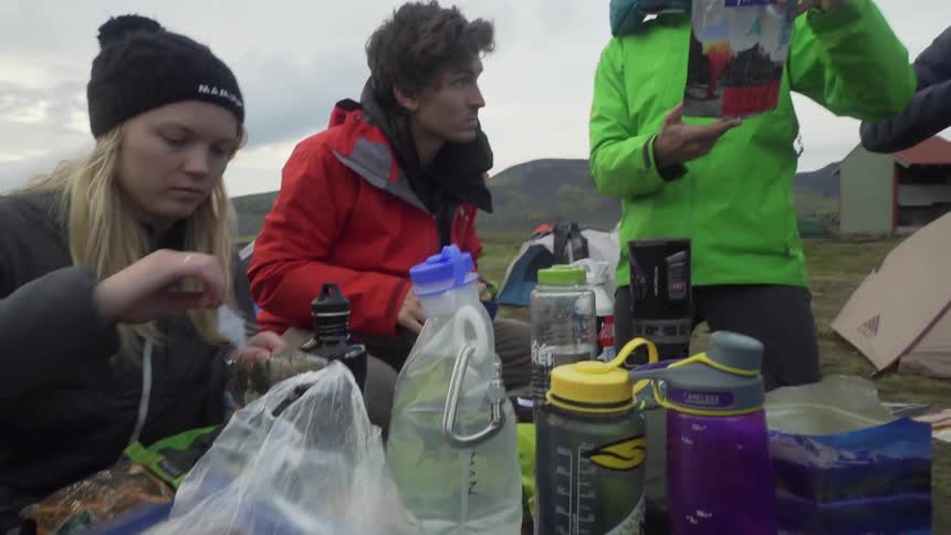 A group of campers sorting through their food and water supply