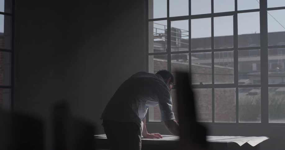 A man that is writing on a piece of paper in an office