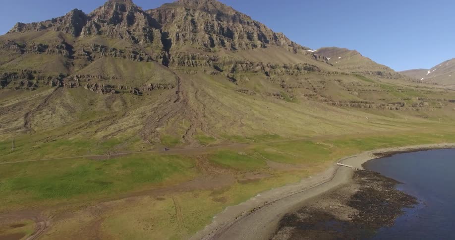 A car is driving along a mountain