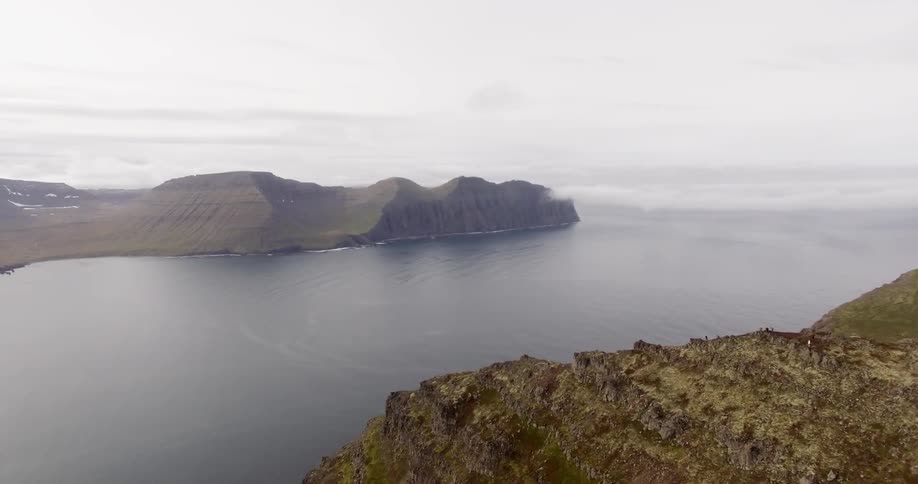 Clouds floating over a mountain and body of water