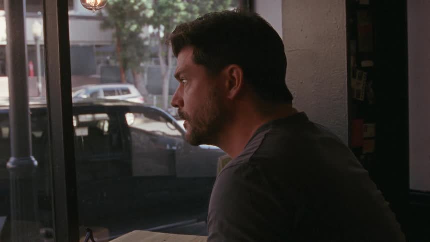A man stares intently out a restaurant window