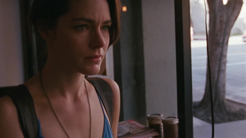 A woman walks into a cafe, approaches a man at a table and hands over her key and a wedding ring