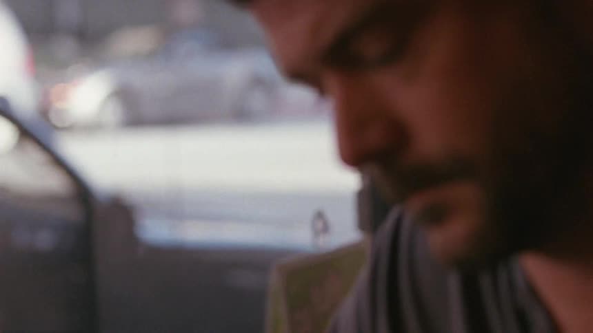 Bearded man contemplating something while the city moves on out the window