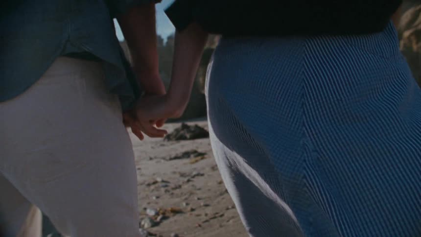 Couple walking on a beach while holding hands