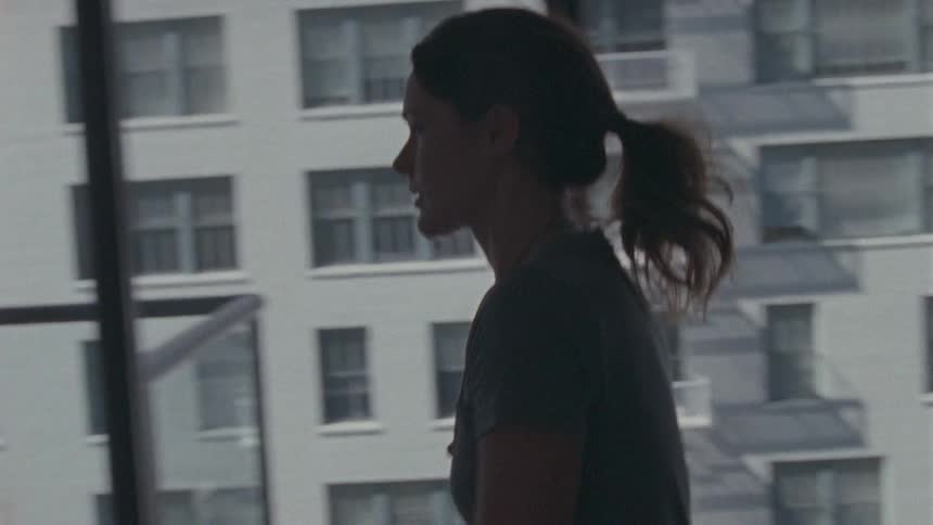 A woman unpacks boxes by her window