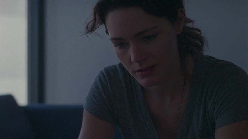 A woman sits sighing and talking with someone