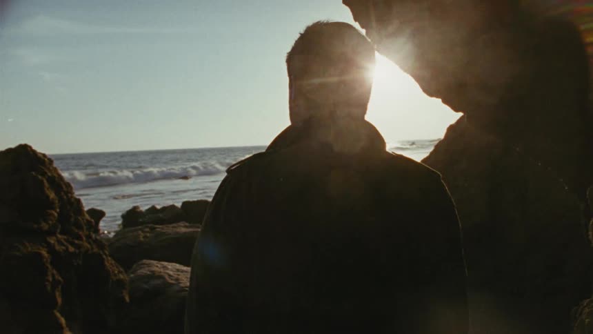 A man walking on a rocky beach