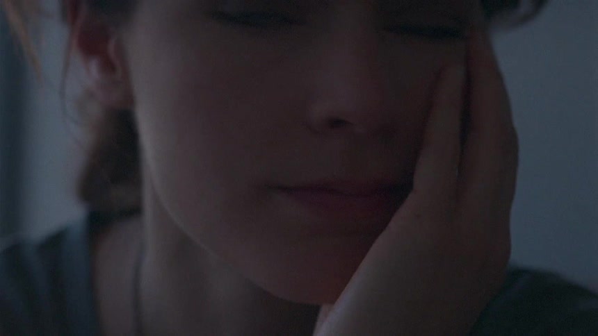 A woman sitting and leaning her head in her hand
