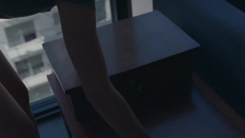 A woman moves the table and places the phone on top of it