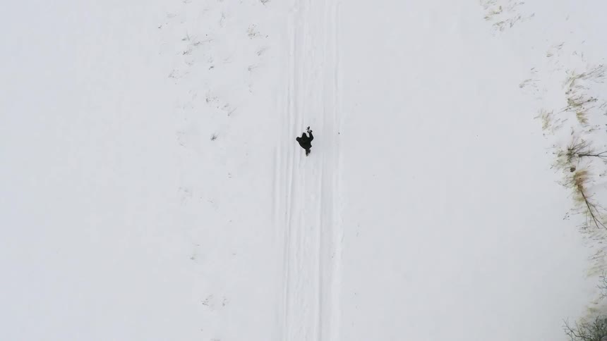 A bird's-eye-view of someone walking through snow
