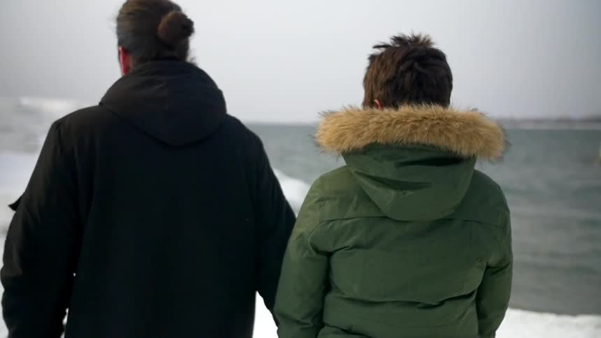 Interracial couple stands by icy water