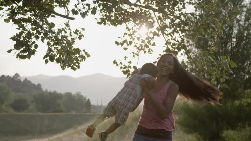 An adult twirling a child in their arms