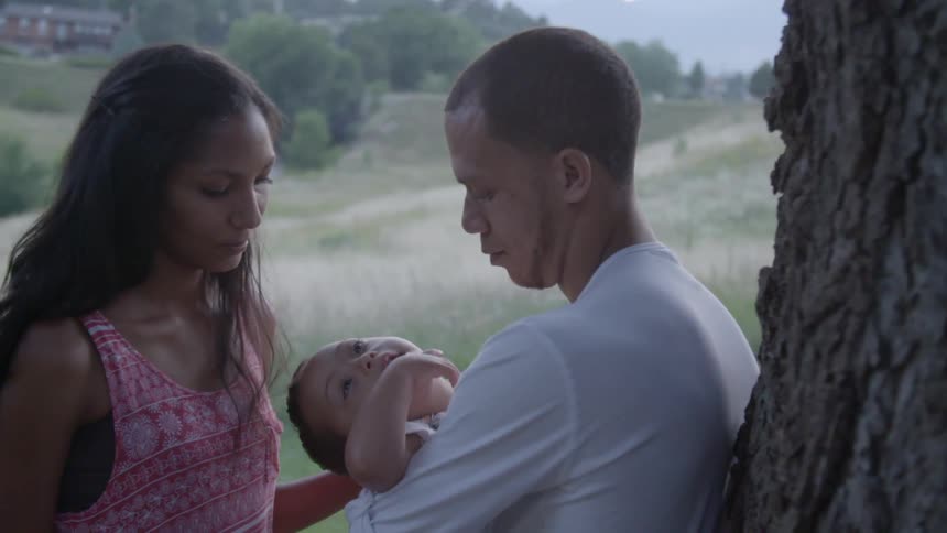 A man and a woman look at their child