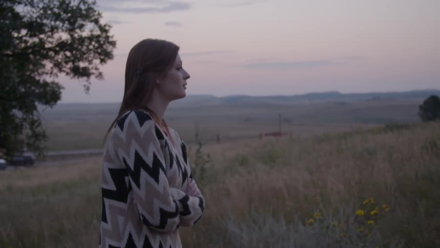 A woman walking through a grassy field