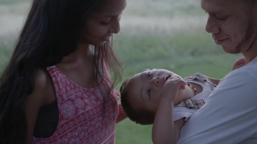 A couple holding a baby together