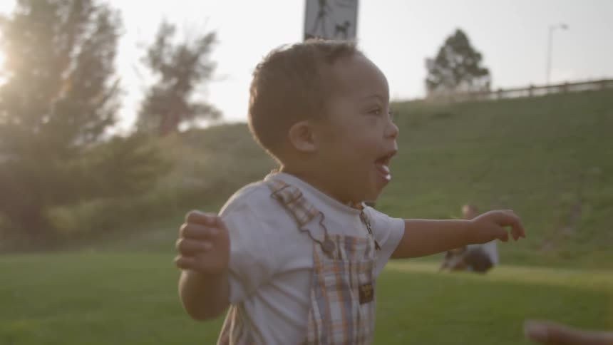 A little boy walks in excitement to his mother