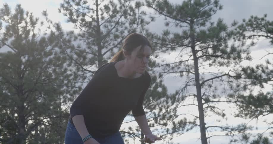 A woman is walking through a field