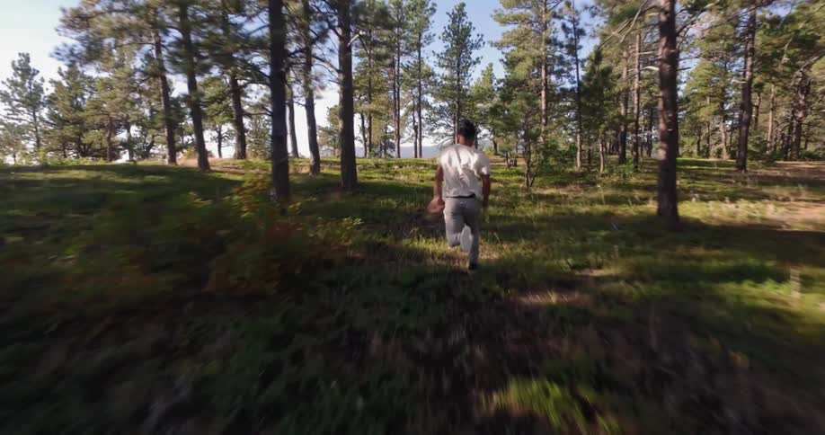 A young man running through a wooded area