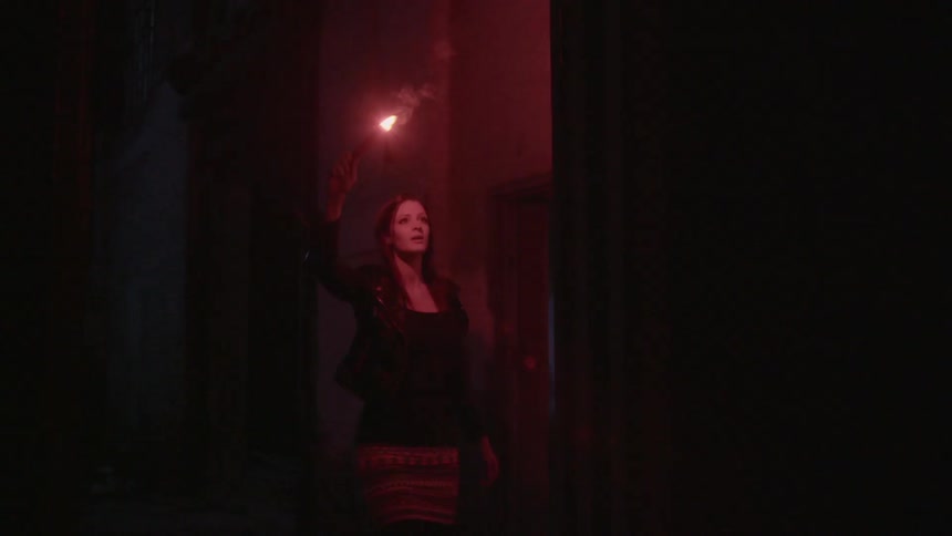 A woman using a flare to illuminate a wall she is studying