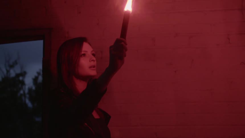 A woman is holding a flare