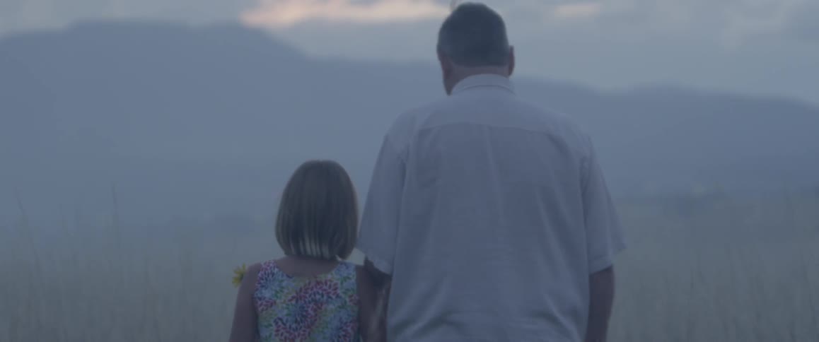 Father and daughter walk toward the mist