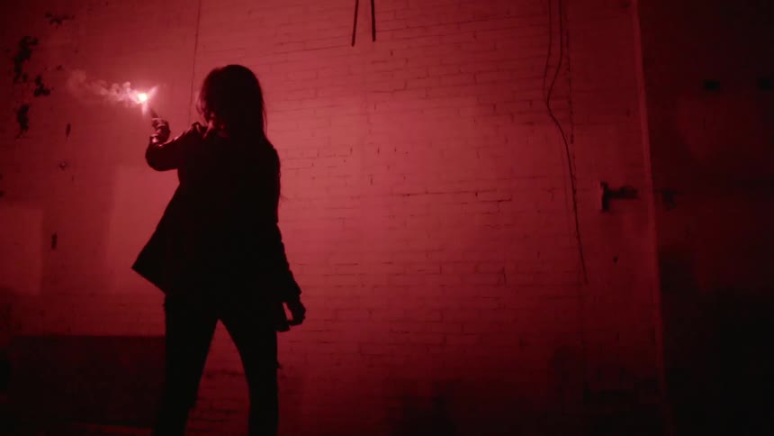 A person uses a flare to light a wall and look at it