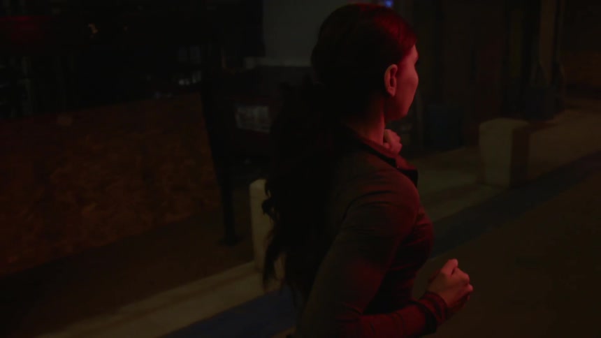 A woman jogs at night in an urban setting