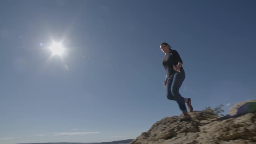 A woman  is running off a cliff