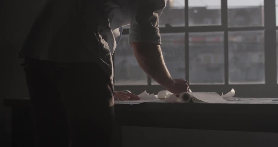 A man looks for a piece of paper and picks it up