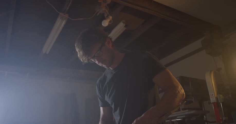 A man measuring a piece of wood in a shop