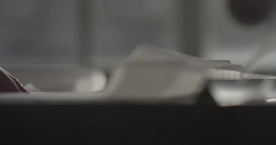 A person is tearing off sections from a roll of paper and making notes on them